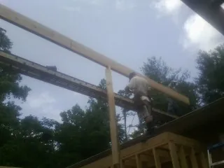 Carpenter setting a ridge beam over a new addition frame — Ice Dam Removal by Roofing Brothers in Vinita