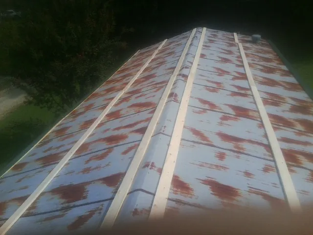 Rusted metal roof panels with new wood purlins before replacement — Storm Damage Roof Repair in Vinita by Roofing Brothers