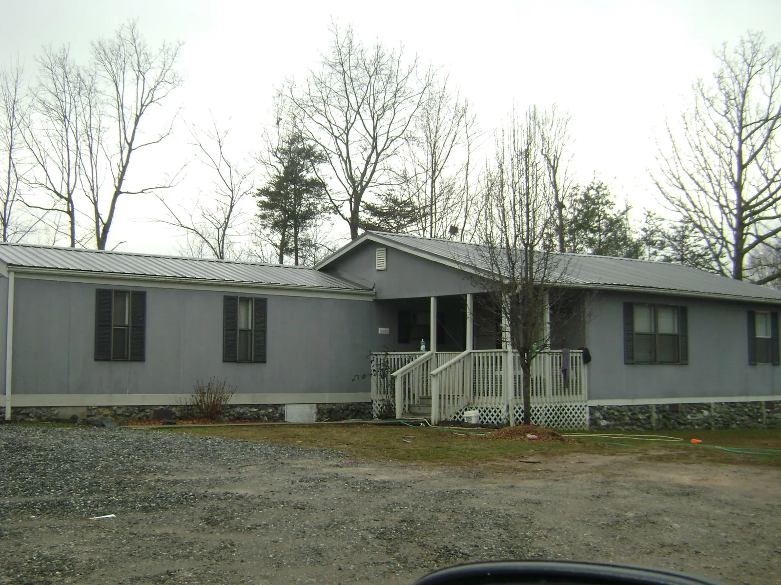 Metal roof over a manufactured home with a covered front porch in Vinita