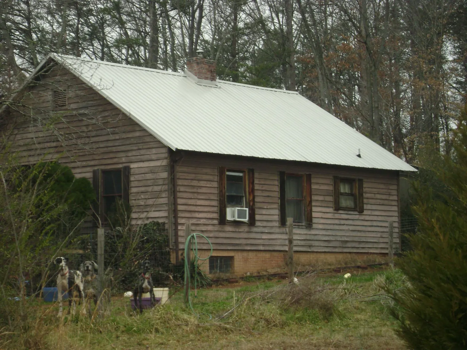 White metal roof on an old wood sided farmhouse, from a Asphalt Shingle Roof Repair job in Vinita